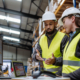 Warehouse Manager Talking With Logistics Employee In Warehouse